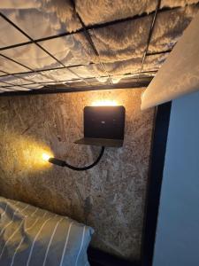 a room with a bed and a tv on a wall at Mãe Maria House Guest House in Vila Chã