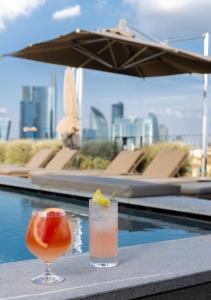 a drink sitting on a table next to a pool at Hotel VIU Milan, a Member of Design Hotels in Milan