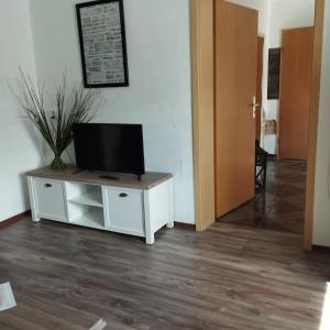 a living room with a tv on a white cabinet at Fewo Am Waldrand in Heideblick