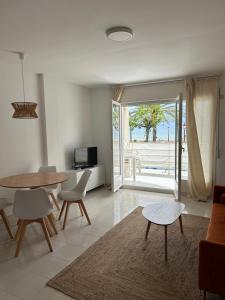 a living room with a table and chairs and a patio at Right on the beach in Cubelles