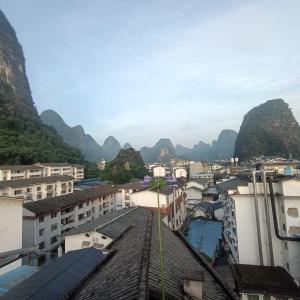 a view of a city with mountains in the background at Yangshuo How Flowers Hostel & Party Coliving Coworking Nomads in Yangshuo