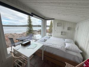 a bedroom with a bed and a desk and a window at Aurora Camp Kiruna in Kiruna