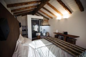 a bedroom with a white bed in a room with wooden ceilings at Chambres d’hôtes La Latteria in Torgnon