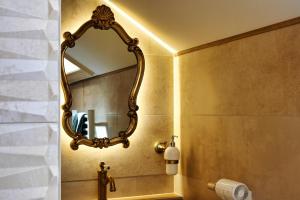 a bathroom with a large mirror on the wall at La Suite Enchantée in Valentigney +22 photos