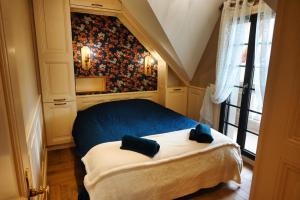 a bedroom with a bed with two blue pillows on it at La Suite Enchantée in Valentigney