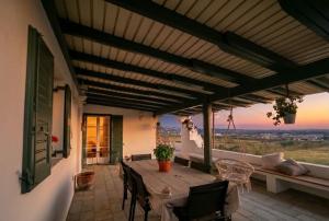 an outdoor patio with a wooden table and chairs at Villa Ioanna in Agkidia