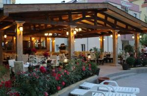 a patio with tables and chairs and flowers at Siana 1 Apartment in Sveti Vlas