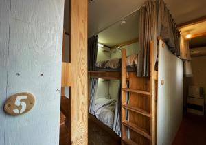 a couple of bunk beds in a room with a ladder at SappoLodge in Sapporo