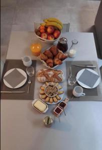 a table with a bunch of food and a bowl of fruit at La terrasse des oiseaux in Taillet +7 photos