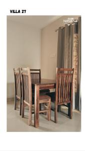 a wooden table and two chairs and a wooden table and chairs at Villa 27 in Sonāpur