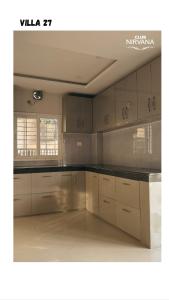 a kitchen with white cabinets and a black counter top at Villa 27 in Sonāpur
