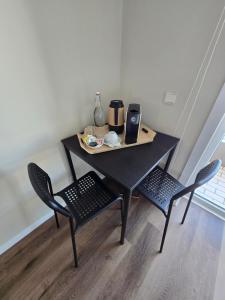 a table with two chairs and a coffee maker on it at Mãe Maria House Guest House in Vila Chã