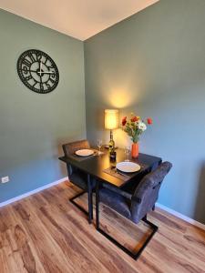 a dining room with a table and a clock on the wall at Mirnockblick Apartments 2 in Radenthein