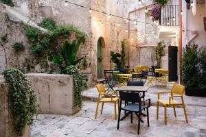a patio with tables and chairs in a courtyard at Nicanto Rooms in Taranto