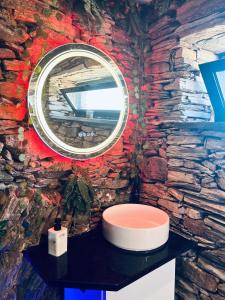 a bathroom with a round mirror on a stone wall at Private Wellness Boa Vista in Vale da Certa +17 photos