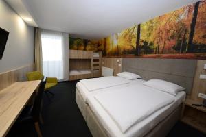 a bedroom with a bed with a painting on the wall at Hotel Alpina in Kranjska Gora +32 photos