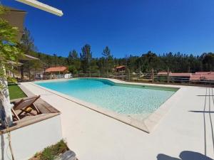 a large swimming pool with blue water in a yard at Private Wellness Boa Vista in Vale da Certa