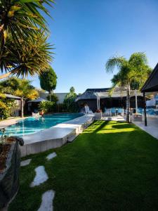 a yard with a swimming pool and palm trees at The Guesthouse in Vanderbijlpark