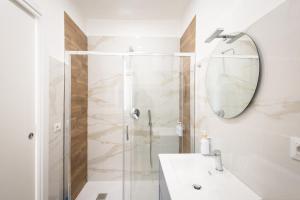 a bathroom with a shower and a sink and a mirror at Azzurra Rooms Suite in Battipaglia