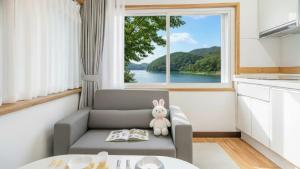 a living room with a chair and a window at Chuncheon El Dorado Kid's Pension in Gapyeong +4 photos