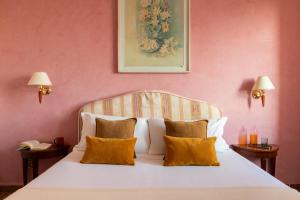 sypialnia z białym łóżkiem i pomarańczowymi poduszkami w obiekcie Hotel La Pace w Pizie +59 zdjęć