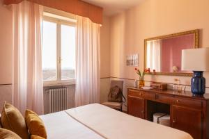 sypialnia z łóżkiem, biurkiem i oknem w obiekcie Hotel La Pace w Pizie