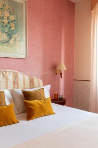 sypialnia z białym łóżkiem i różową ścianą w obiekcie Hotel La Pace w Pizie