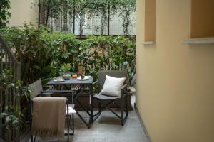 a patio with a table and chairs and plants at Speronari Suites in Milan