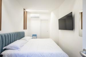 a bedroom with a bed and a flat screen tv at Azzurra Rooms Suite in Battipaglia