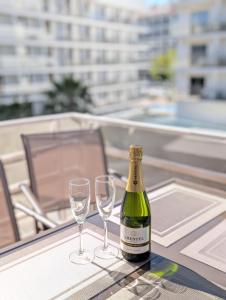 a bottle of wine sitting on a table with two glasses at Tropical Salou in Salou