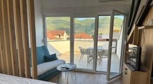 a room with a couch and a table and a balcony at VILA PERLA in Trebinje
