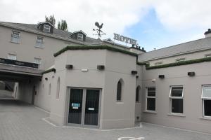 um edifício branco com uma placa no topo em The Enniskillen Hotel and Motel em Enniskillen