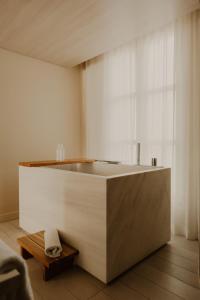 a bath tub in a room with a window at Hotel de Nell in Paris +40 photos