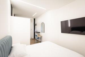 a bedroom with a bed and a tv on the wall at Azzurra Rooms Suite in Battipaglia