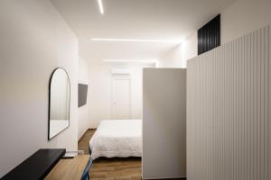 a white bedroom with a bed and a mirror at Azzurra Rooms Suite in Battipaglia