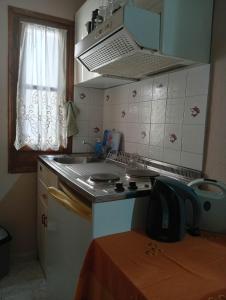 a kitchen with a sink and a stove and a window at Irida mariaSmall studio in Agios Ioannis Pelio