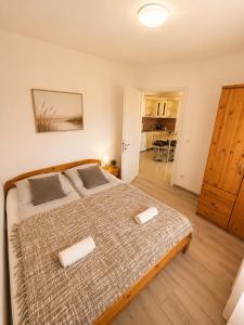 a bedroom with a large bed with two towels on it at AH-Corso Wellness Apartment in Siófok +24 photos