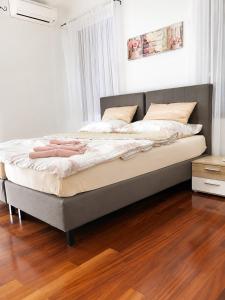a large bed in a bedroom with a wooden floor at Losinj Panorama Penthouse in Mali Lošinj