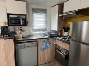 a kitchen with a stainless steel refrigerator and a sink at Mobil home 459 in Pont-Aven