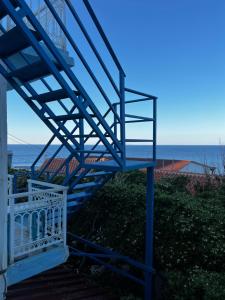 a blue staircase on a house with the ocean in the background at Sufiko Studios - Thea in Armenistis +5 photos