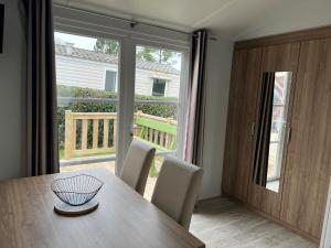a dining room with a table and a large window at Mobil home 459 in Pont-Aven