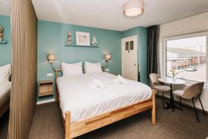a bedroom with a bed and a table and a window at Divi Divi Zandvoort in Zandvoort