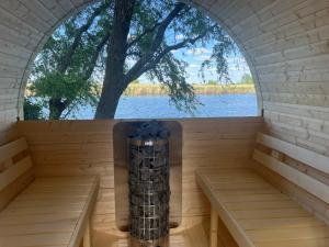 a sauna with a window overlooking the water at Waterside Cottage in Nagyrév