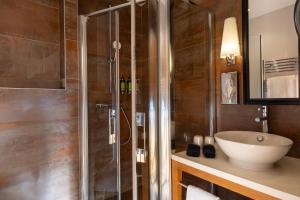 ein Badezimmer mit Dusche und Waschbecken in der Unterkunft Hotel Le Six in Paris