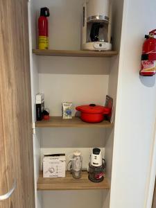 a pantry with wooden shelves with various kitchen items at Mobil home 459 in Pont-Aven