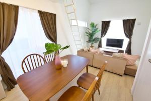 a dining room table and chairs in a living room at Dual Residence Nakijin A in Koechi