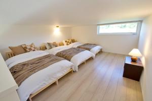 a bedroom with three beds and a window at Dual Residence Nakijin A in Koechi