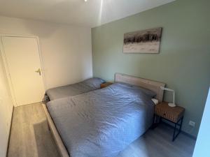 a small bedroom with a bed and a night stand at Casa Ghentele in Blankenberge