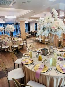 a banquet hall with tables and chairs and flowers at Apartamenty Branicka in Białystok