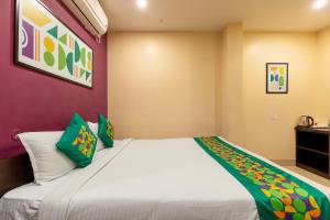 a bedroom with a large white bed with green pillows at Treebo Hotel Mobi VIP Airport in Guwahati +36 photos